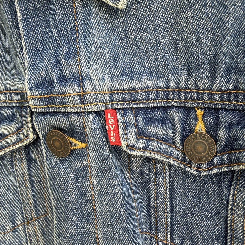 Détail de la patte de boutonnage et de l'étiquette rouge